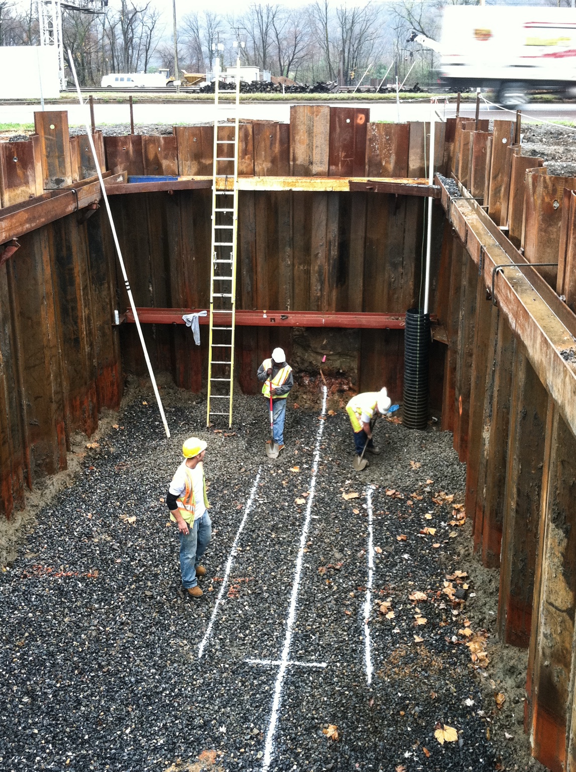 Crew handling pipe in trench