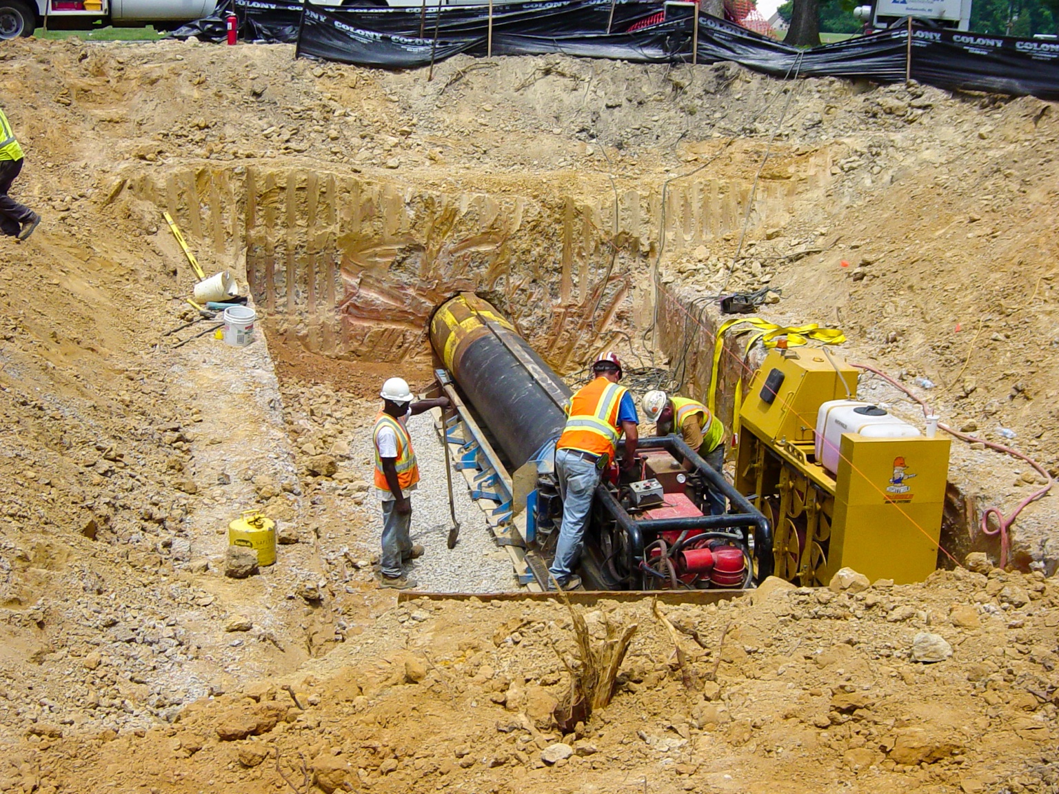 Crew working in muddy trench conditions